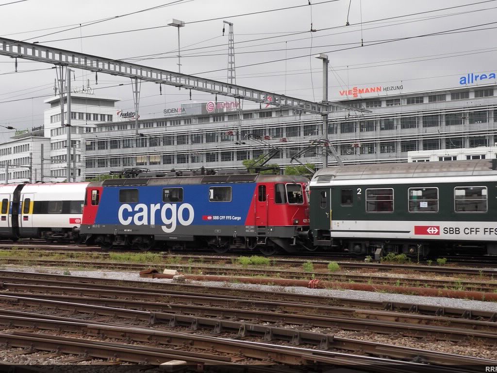 Re 4/4 in the cargo scheme heading a train out of Zurich Main Station.
