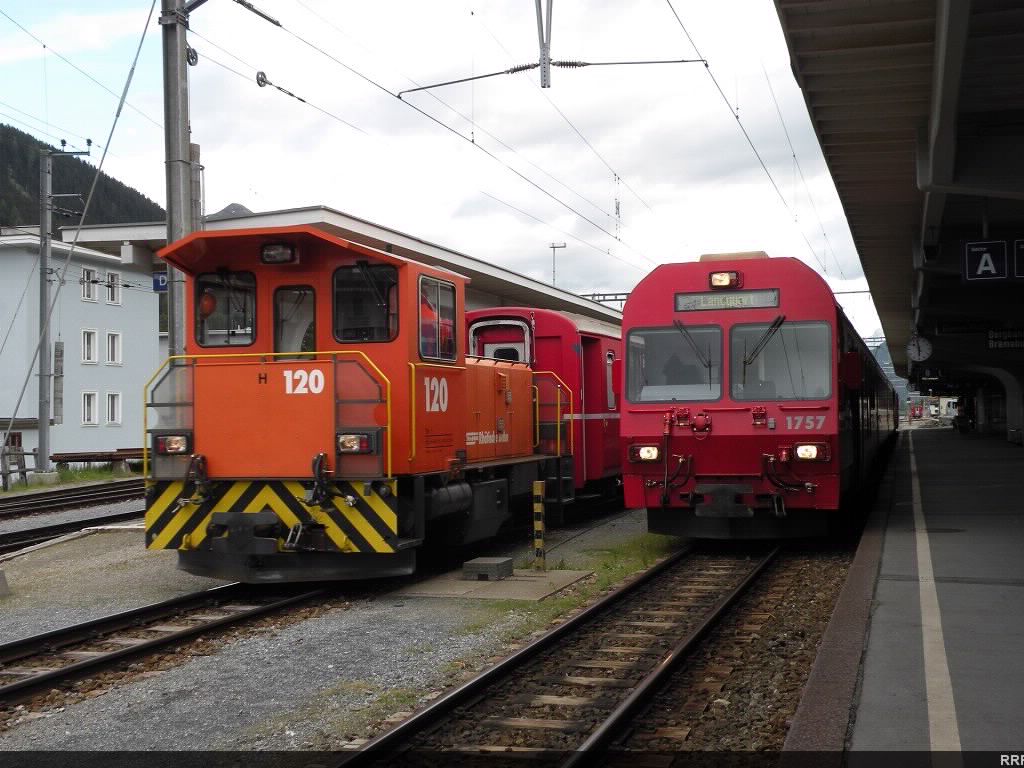 Diminutive Class Tm2/2 diesel switcher and the cab car of the Landquart bound train. 