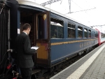 Time honored scene of a conductor checking his schedule, wating for the train to leave, 