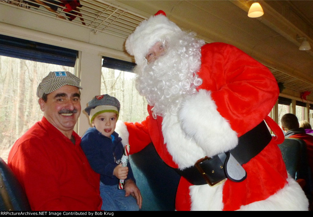 Grandpa, grandson, and Santa enjoying the ride (and the candy cane)