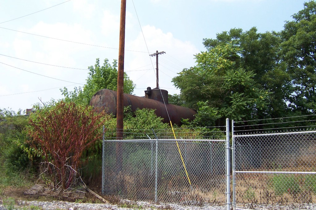An old tanker sleeps in the trees as a water hole