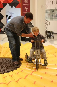 A visitor enjoys MoMath's square-wheeled tricycle.