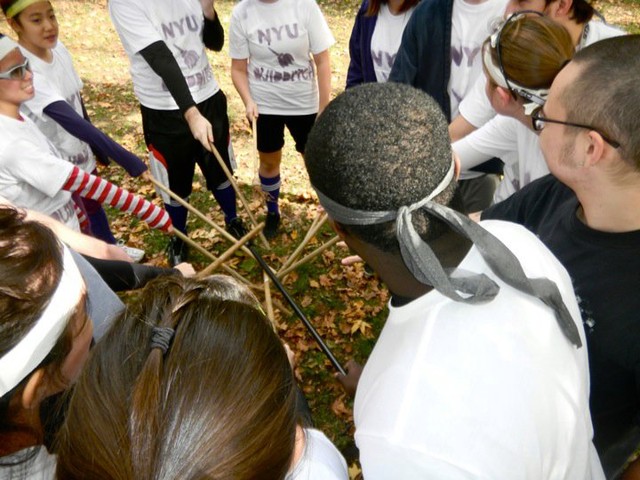 The NYU Quidditch team huddles with their 