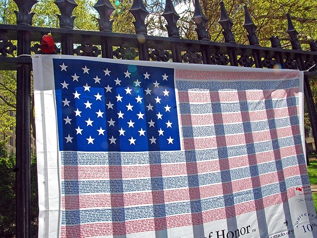 A flag bearing the names of 9/11 victims hangs on a fence across from Ground Zero.