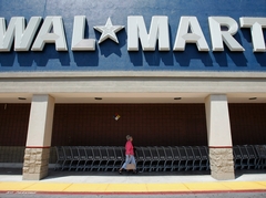 Walmart co-manager, Mary Brinkley, adjusts a sign on a computer display in her store in Richmond, Va.