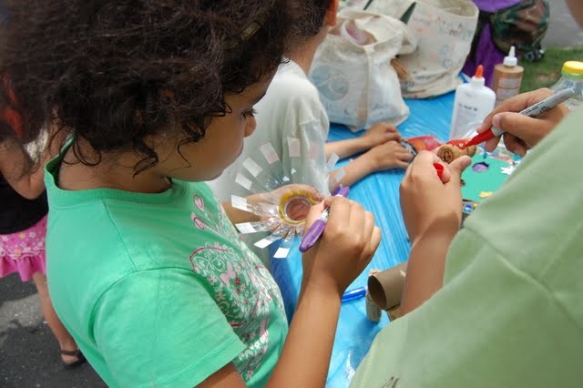 Child at arts and crafts station at teh Sunken playground.