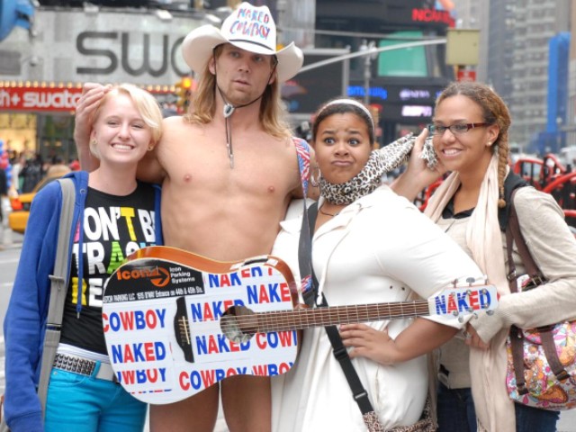 Naked Cowboy, Robert Burck, poses with fans.
