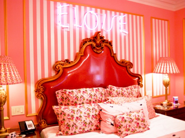 Eloise's name is scrawled in neon pink lights above the bed.