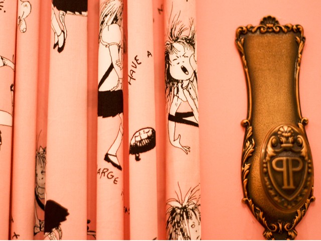 The drapes covering the bathroom doors are covered in little Eloises, as illustrated by Hilary Knight.