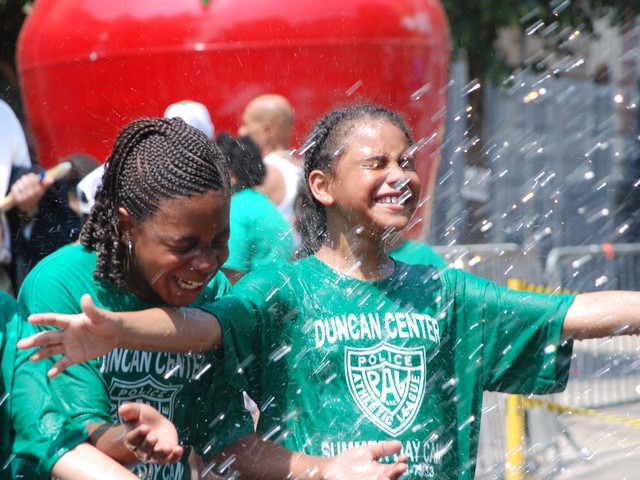 Siera Traore (center), 10, of New Jersey and Trinity Torres (right), 9, of the Bronx find relief from the triple-digit temperatures in the water sprayed from a fire hydrant. Attorney Robert Morgenthau and Police Commissioner Raymond Kelly struggled to open the hydrant moments earlier.