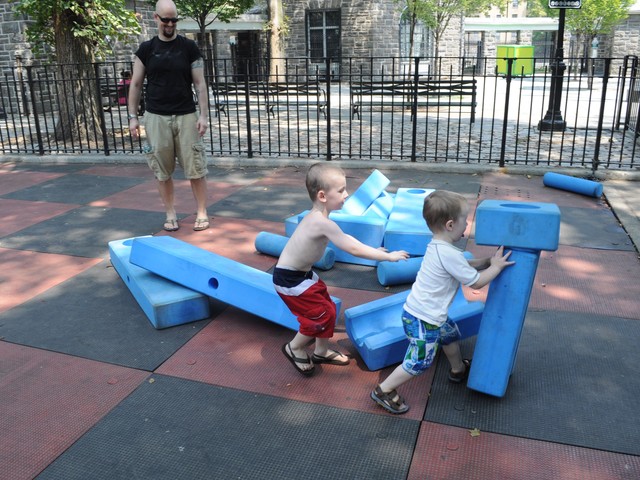 Owen and Liam Wells knock down blocks at the playground.