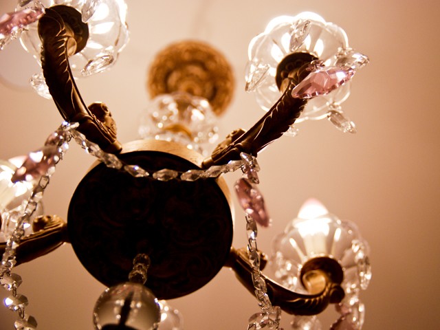 A chandelier in the bathroom is decked-out in pink.