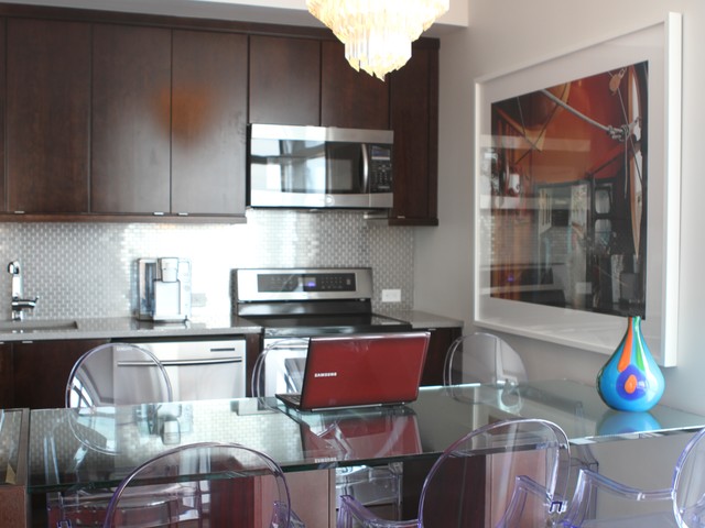 The ultramodern kitchen is by a living room furnished with antiques.