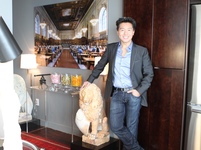 Interior designer Vern Yip leans against an antique marble lion in the foyer.