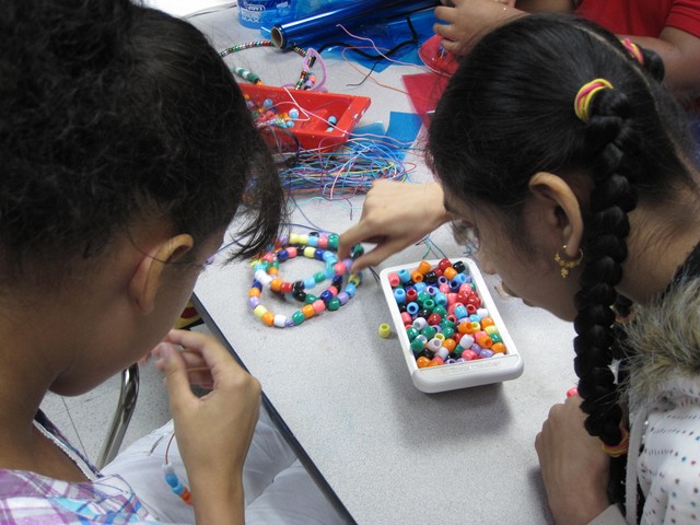 Valerie Liranzo, 14, and Kalsoom Ali, 14, make necklaces with beads at an art class for Jewish Guild for the Blind students.