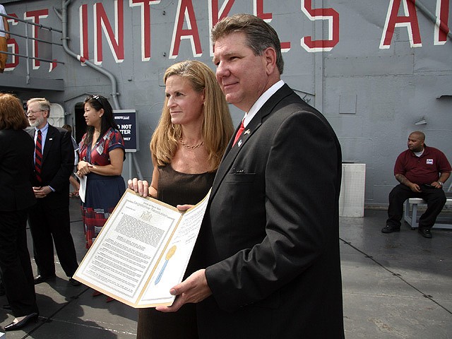 Assemblyman Michael DenDekker and Intrepid executive director Susan Marenoff hold a state resolution supporting the carrier's bid for a space shuttle.