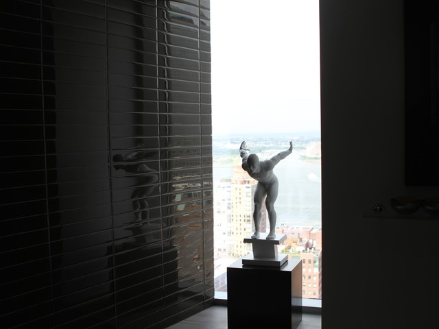 In the bathroom, a sleek black and white design is paired with a Lladro 
