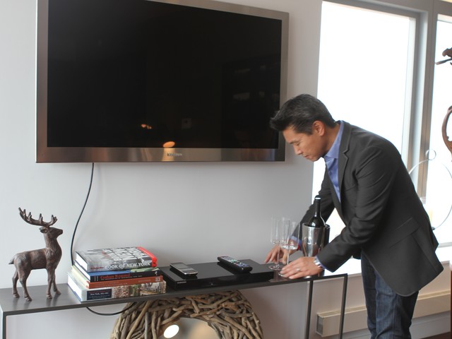 Designer Vern Yip meticulously arranges the ornamentation that comes with the apartment.
