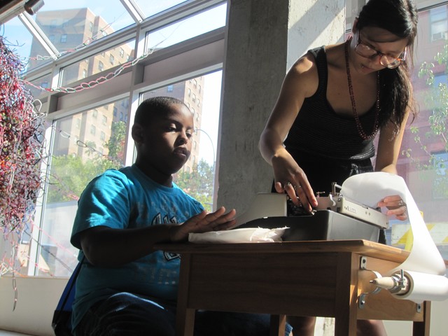 Paul Gaston, 11, gets help on one of the interactive exhibits from intern Selina Lee.