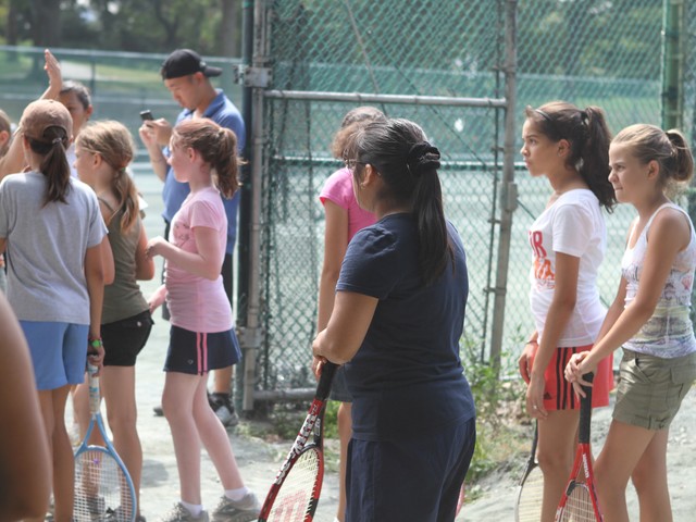 A group of girls look on to support their teammates during the tennis competition Tuesday.