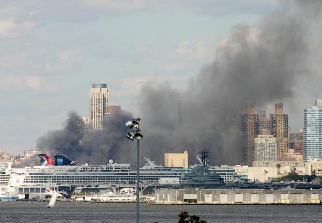 Smoke rises from the Hudson River  after fire broke on a pier operated by the Sanitation Department, Saturday, Sept. 4, 2010.