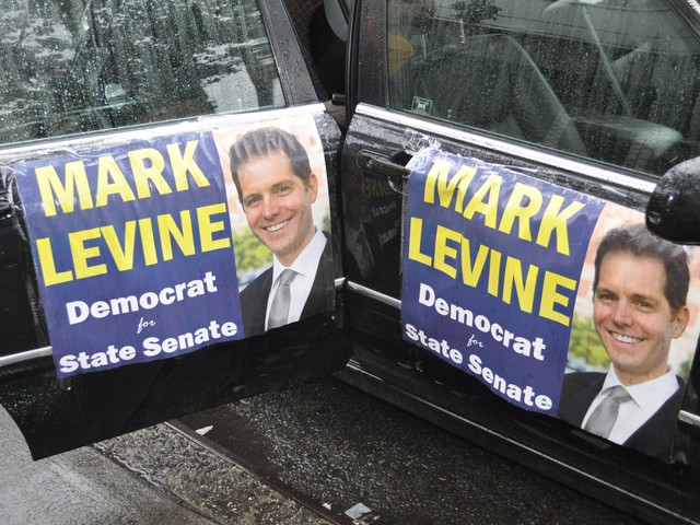 Car doors decorated with Levine posters.