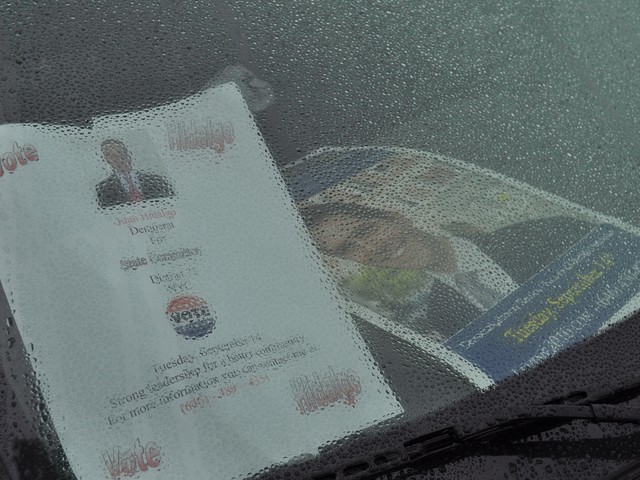 Posters inside one car at the Levine caravan are hidden by rain droplets on the windshield.