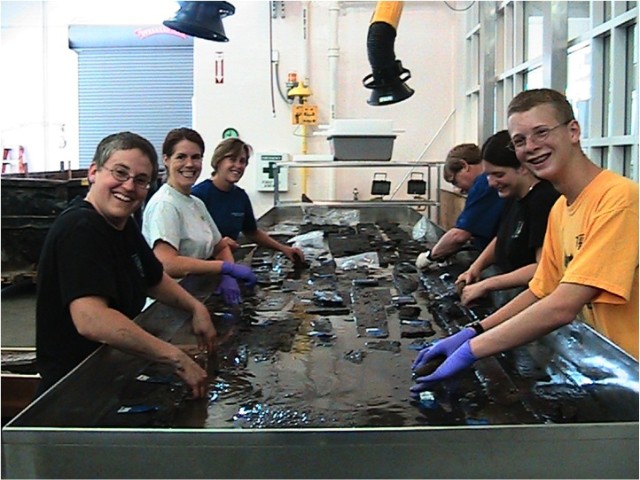 Conservators clean the wood timbers at the Maryland Archaeological Conservation Laboratory.