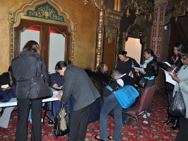 Dozens of people stood in corners and around tables filling out applications for jobs.