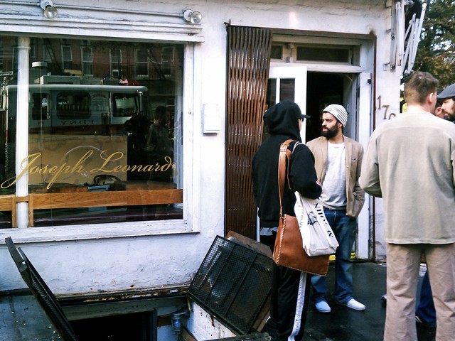 Restaurant owner Gabriel Stulman (pictured in front of the door) inspects the damage.