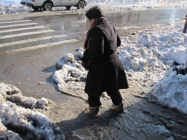 A pedestrian plows through the puddle undeterred.