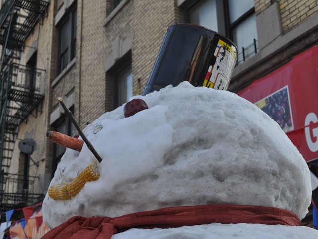 Suarez's snowman wears a pail as a hat, a carrot for a nose, buttons out of Oreo cookies and two eyes made out of apples.