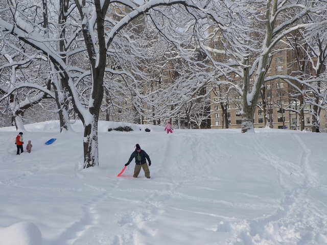 Dad Scott Goldstein clears a path for sledder Serena Goldstein, five, in Central Park.