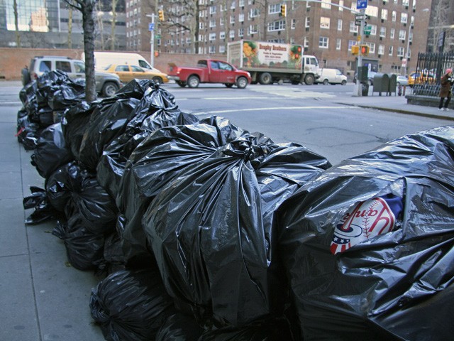 Trash had still not been picked up  Monday morning on 59th Street between Ninth and Tenth avenues.