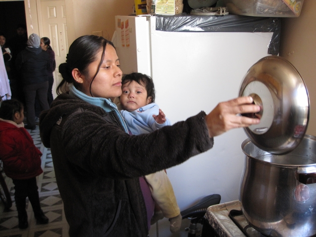 Isabel Cano, 21, checks the pots of boiling water in her kitchen. She says the lack of heat and hot water has made her 9-month-old son Jonathan sick.