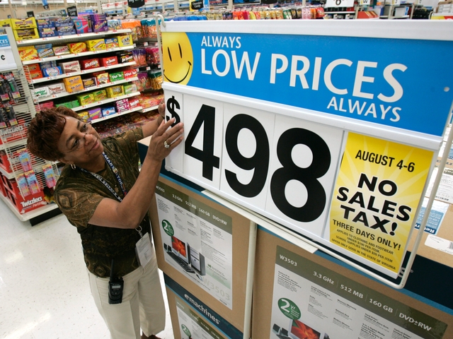 Walmart co-manager, Mary Brinkley, adjusts a sign on a computer display in her store in Richmond, Va.