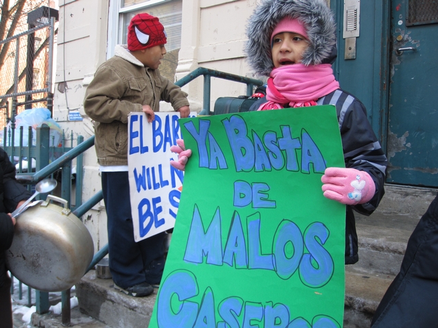 A young resident of 21 E. 115th St. protests outside of her building.