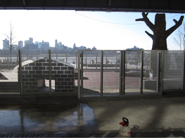 The soon-to-open East River Waterfront park includes an oval dog run with a giant tree and a doghouse.