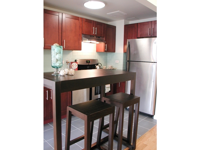 Kitchens at Hudson 192 have dark cherry Shaker-style cabinets with German hinges and soft-self-close drawers and doors.