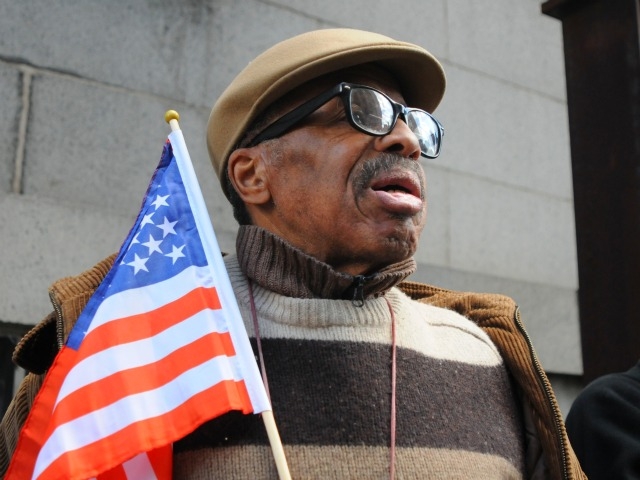 Melvin Bright, 67, of Harlem, waves the flag near Ground Zero Thursday.