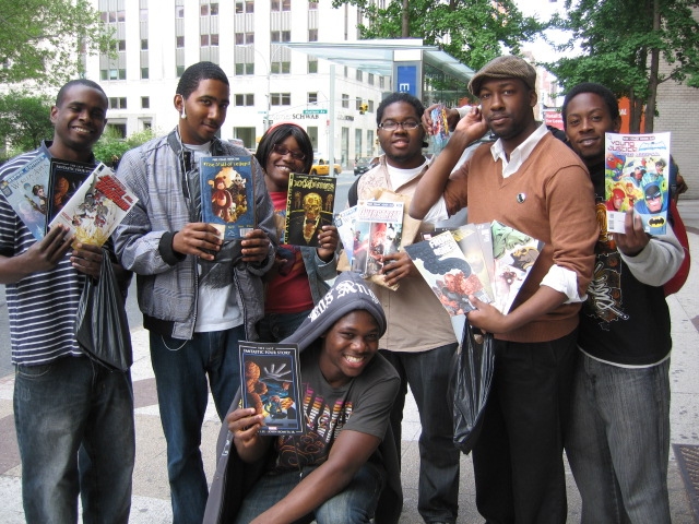 A group of comic fans show off their haul from a day of comic book store-crawling on Free Comic Book Day.