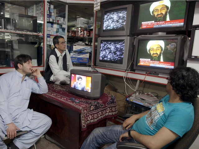 Afghan men working at a TV shop watch the news of the death of accused 9/11 mastermind Osama bin Laden on a TV May 2, 2011 in Kabul, Afghanistan.