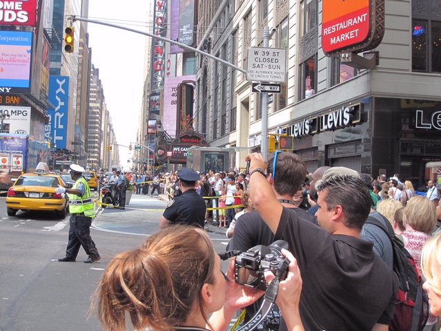 Crowds assemble in Times Square watching a man atop a light pole on Tuesday.