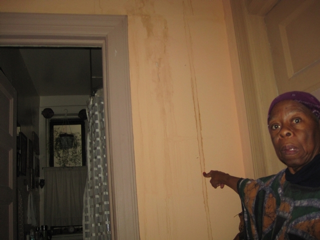 Rashidah Abu Bakr, a Tahl Propp tenant in Central Harlem, shows the water damage in her apartment from a flood she says was caused by improper construction in her building.