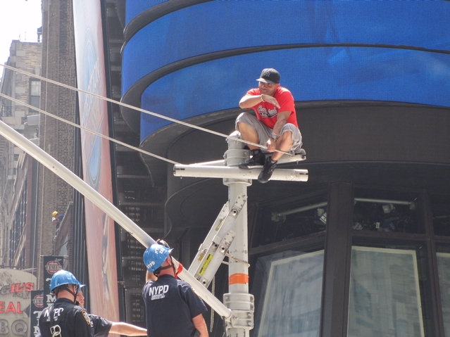An unidentified man points toward where police erected a inflatable air bag for him to fall onto Tuesday.