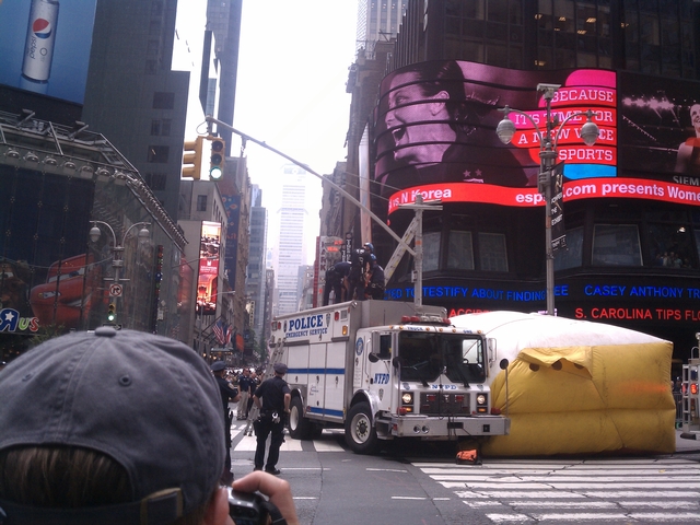 Police handcuffed a rapping man after he spent two hours on a light pole in Time Square forcing traffic closures.