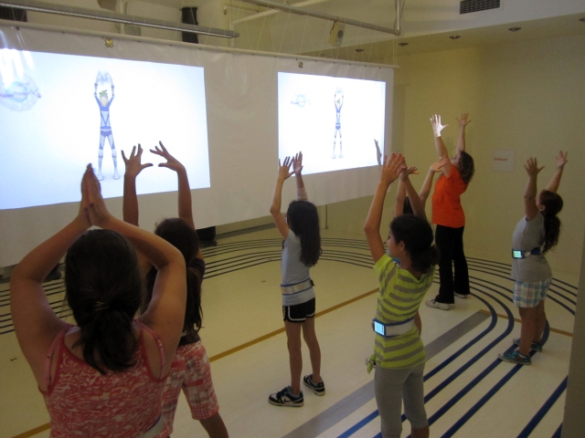 Kids follow on-screen avatars for warm-up instructions.