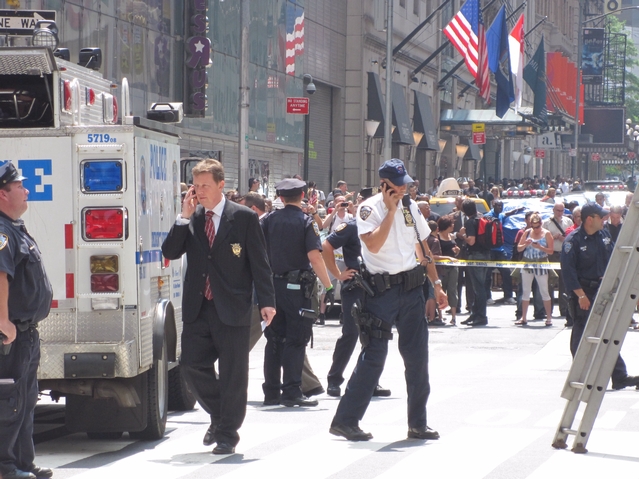 Police arrest man after he climbs down from atop a traffic signal post in Times Square on Tuesday.