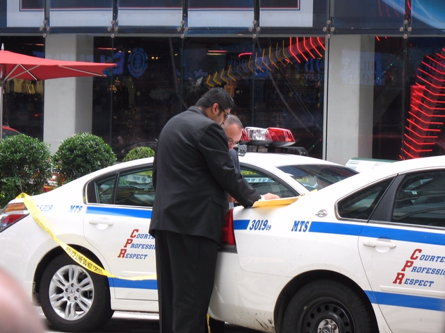 Police go over procedure while a man is atop a light pole in Times Square on Tuesday.
