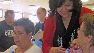 Norma Chavez works attaches a campaign button to the sweater of one of her supporters at an El Paso senior center before the 2010 Democratic primary election.